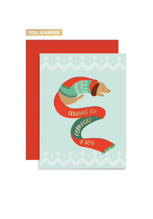 Greeting card featuring a dachshund wearing a sweater and scarf with foil stamping, paired with a red envelope. 