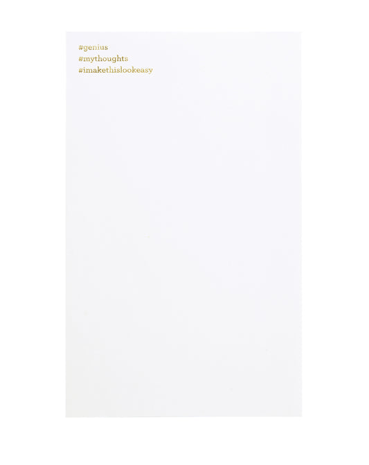 White notepad with gold foil text. "#genius" is printed at the top left, and "#mythoughts" underneath, and "#imakethislookeasy" on the third line. 