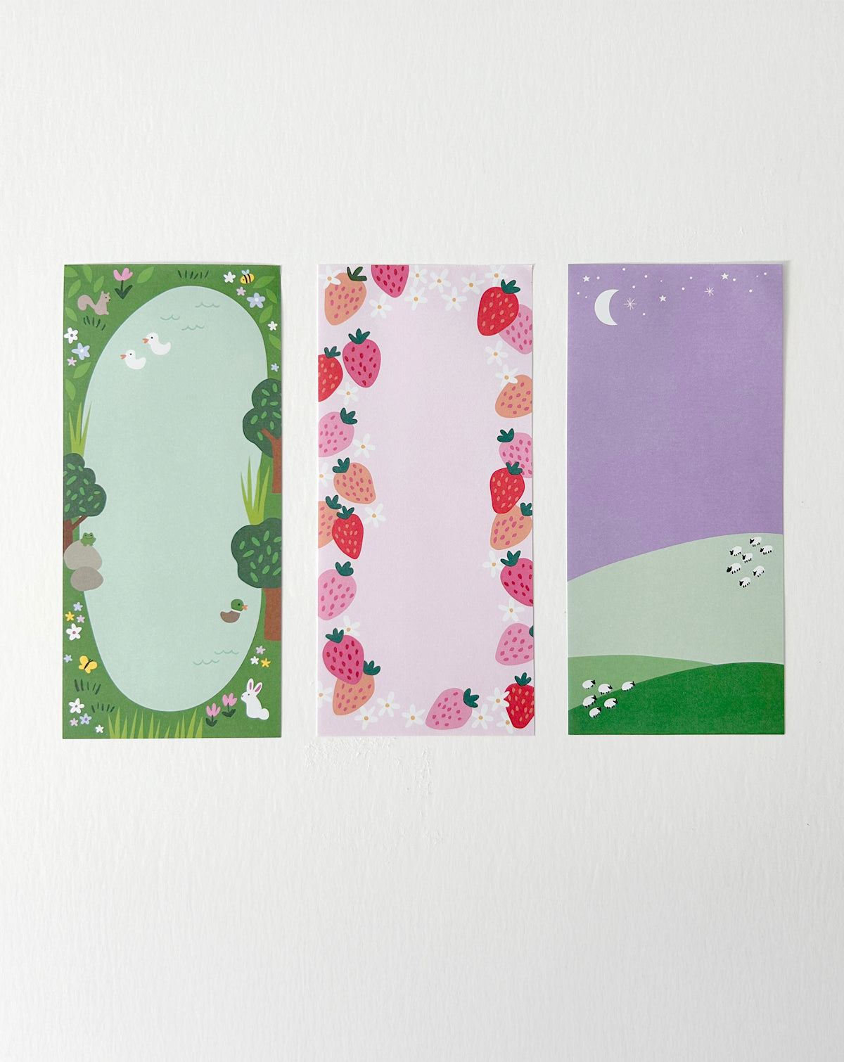 Notepad with three springtime-themed designs, shown with one sheet of each design laid out side by side. 