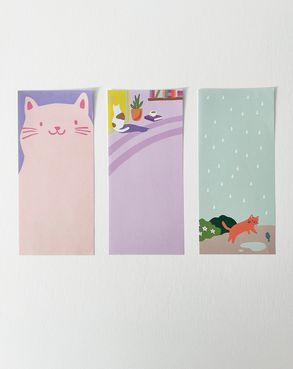 Notepad with three cat-themed designs, shown with one sheet of each design laid out side by side. 