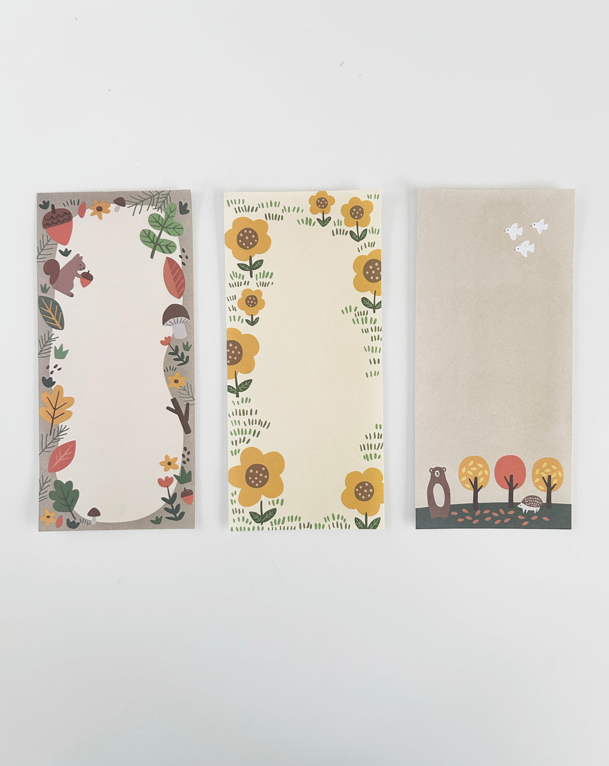 Notepad with three fall-themed designs, shown with one sheet of each design laid out side by side. 