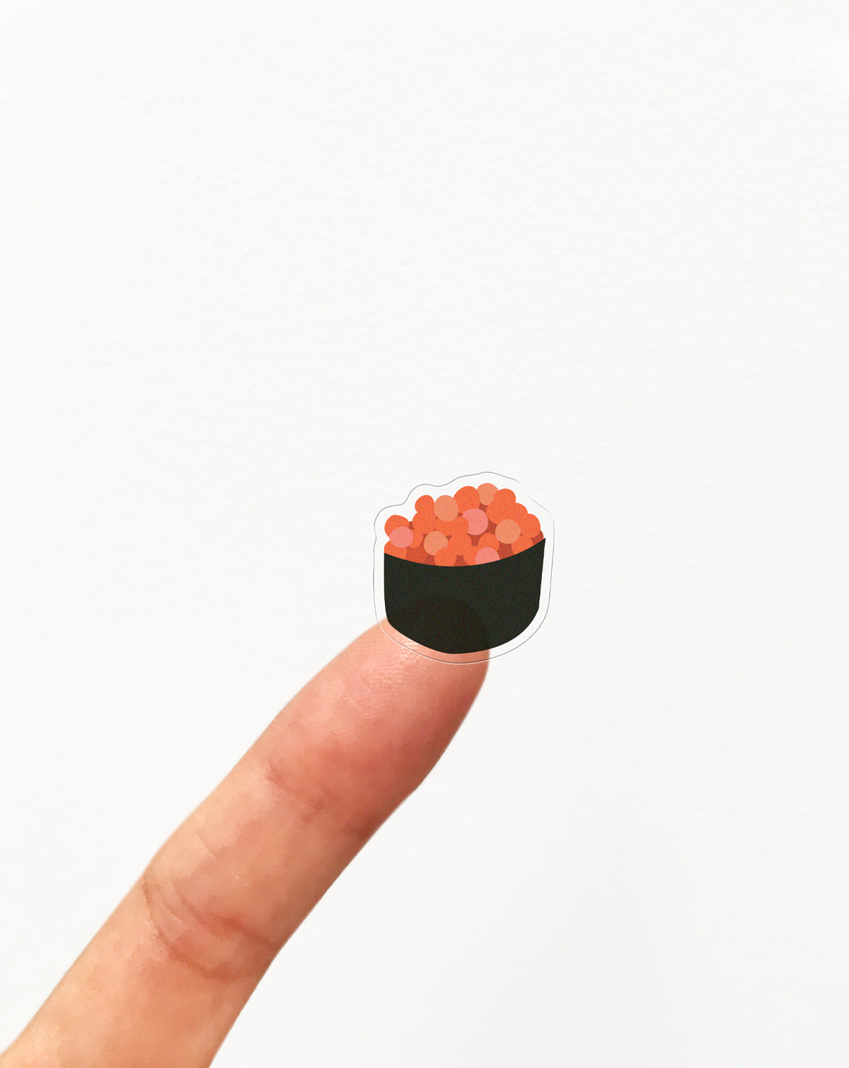 A clear sushi sticker on a finger on a white background