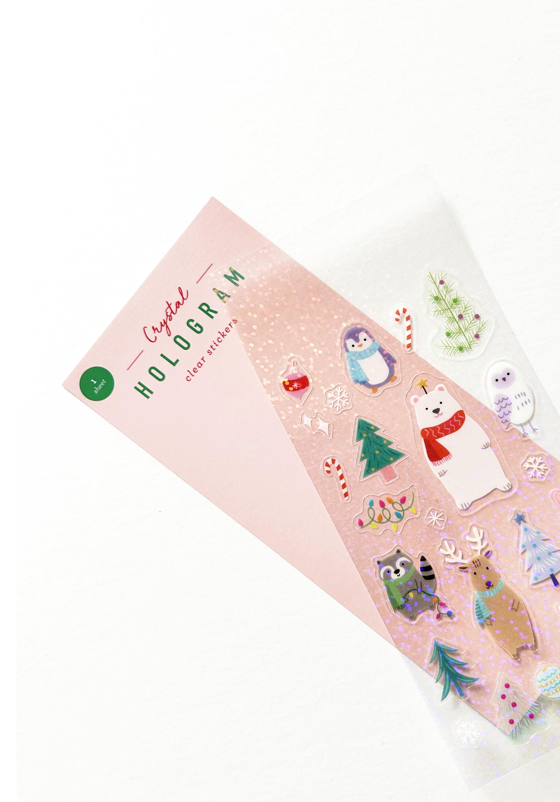 Holographic sticker sheet with holiday animal designs fanned out from packaging card to show texture.