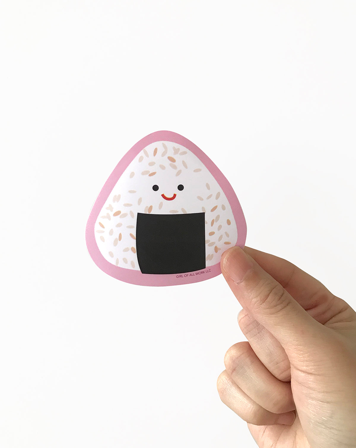 Hand holding a cute onigiri with a smiling face on a white background