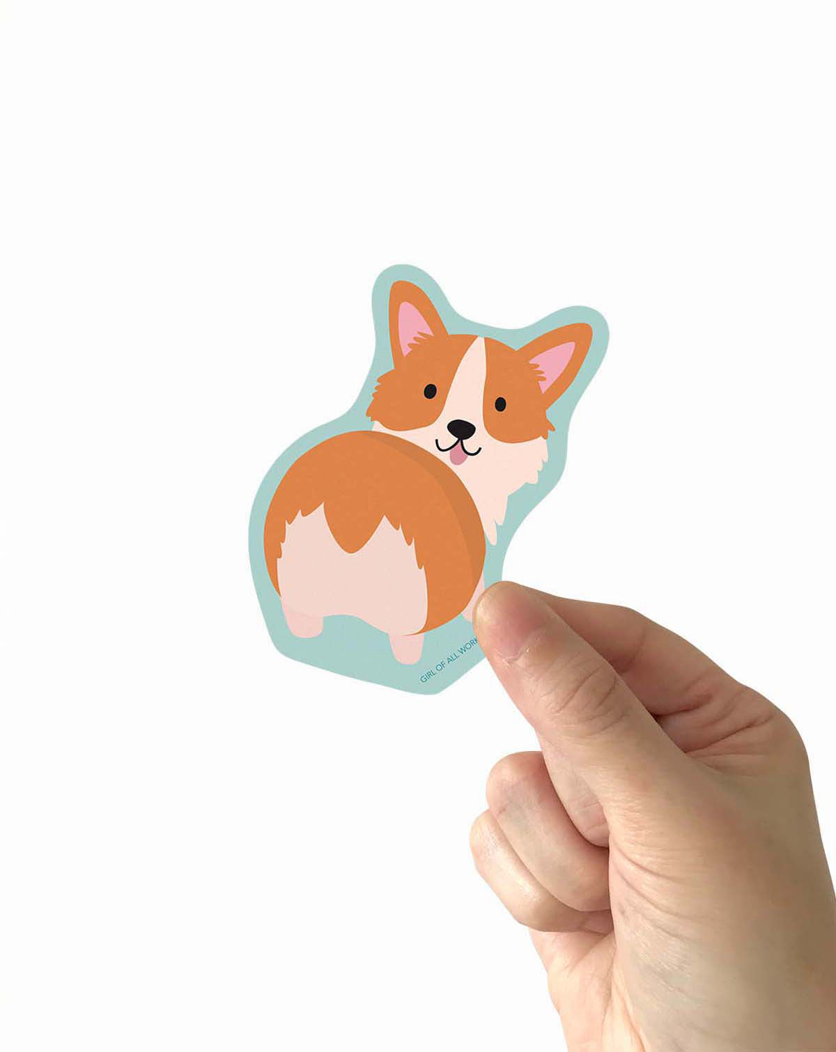 Hand holding a corgi-shaped vinyl sticker against a white background