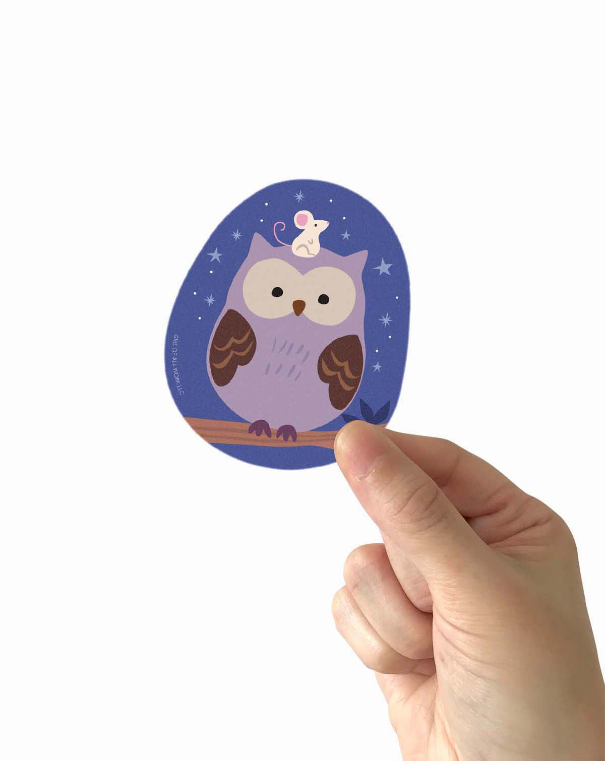 Hand holding a vinyl sticker with an owl design on a white background