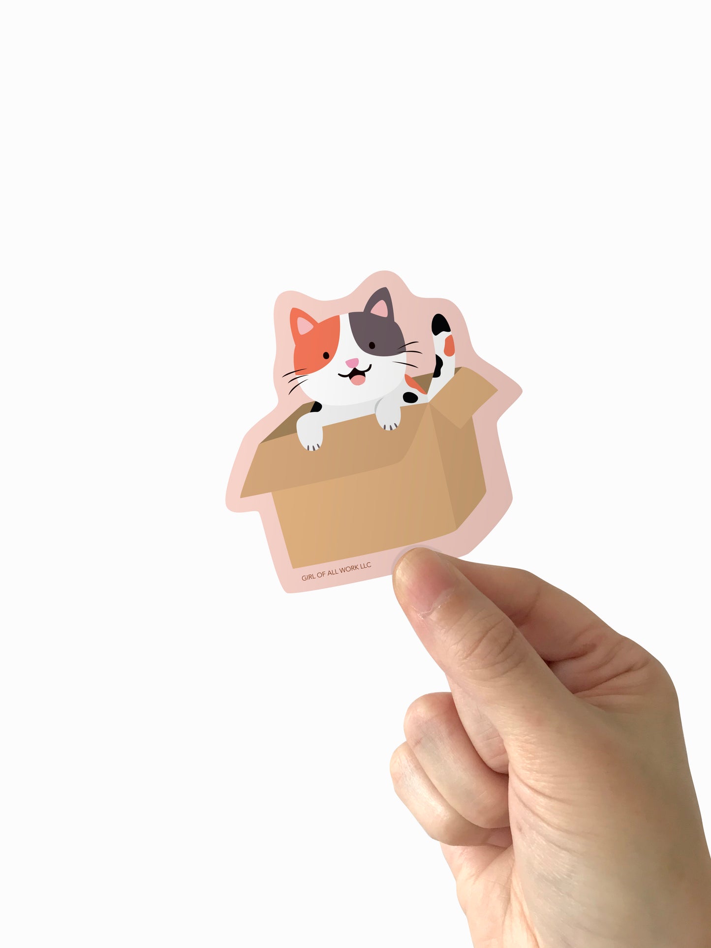 Hand holding a cat-shaped vinyl sticker with a white background