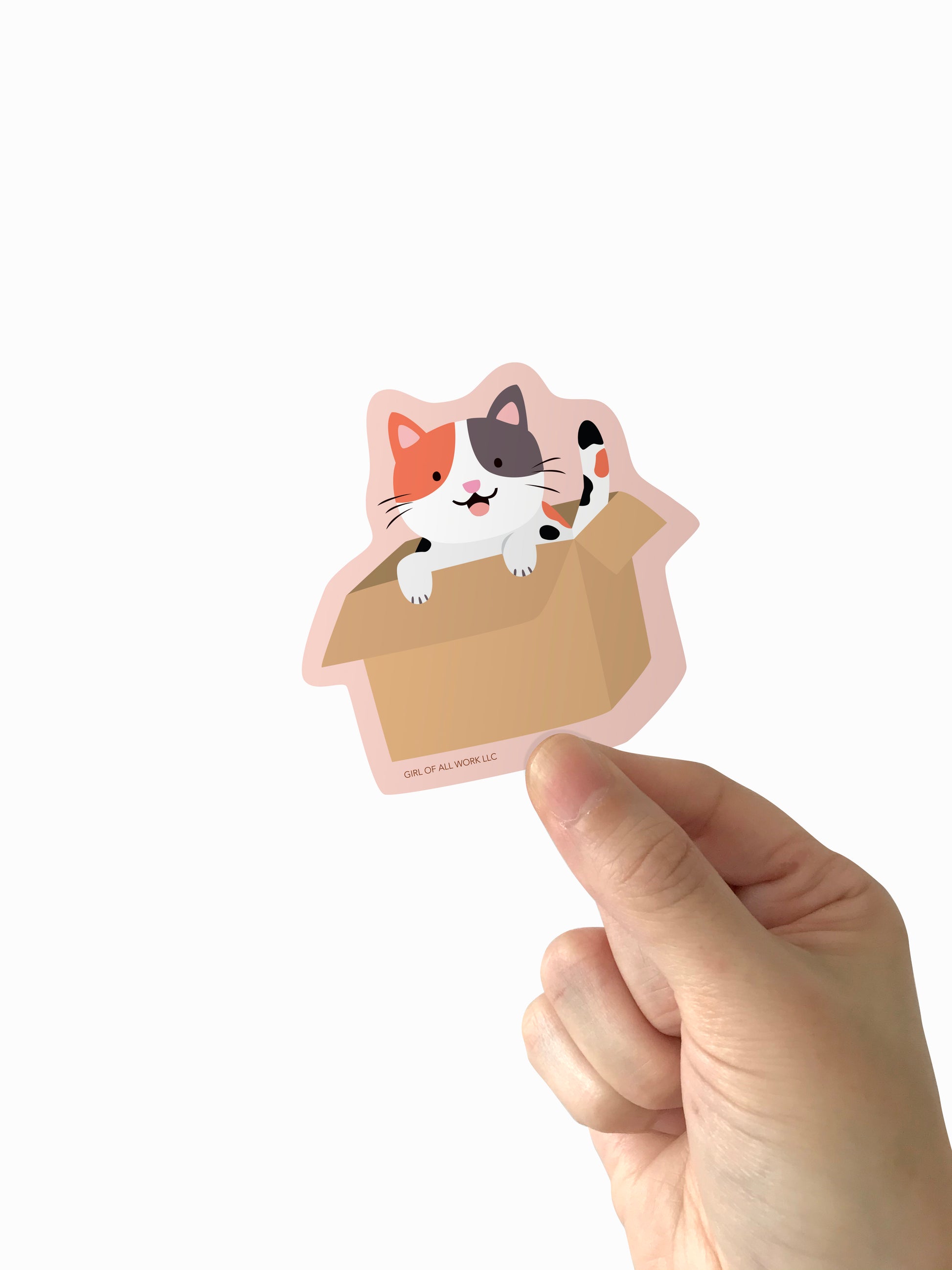 Hand holding a cat-shaped vinyl sticker with a white background