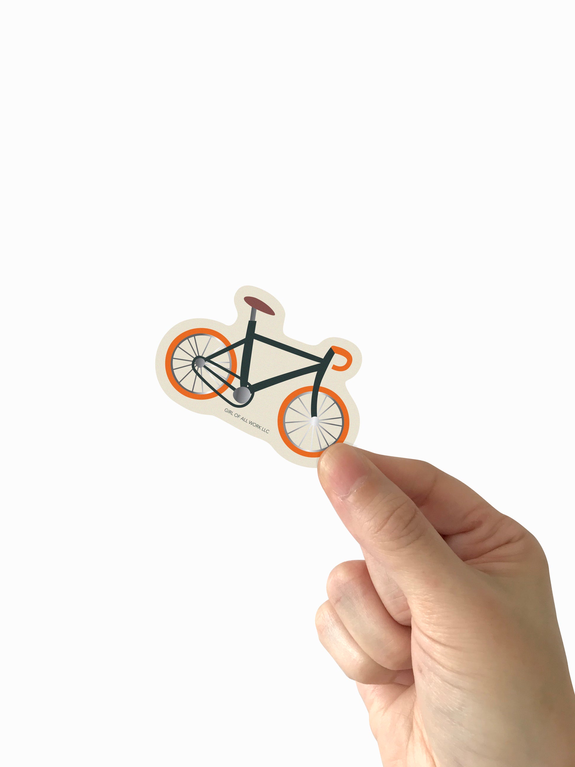 Hand holding a bicycle-shaped vinyl sticker against a white background