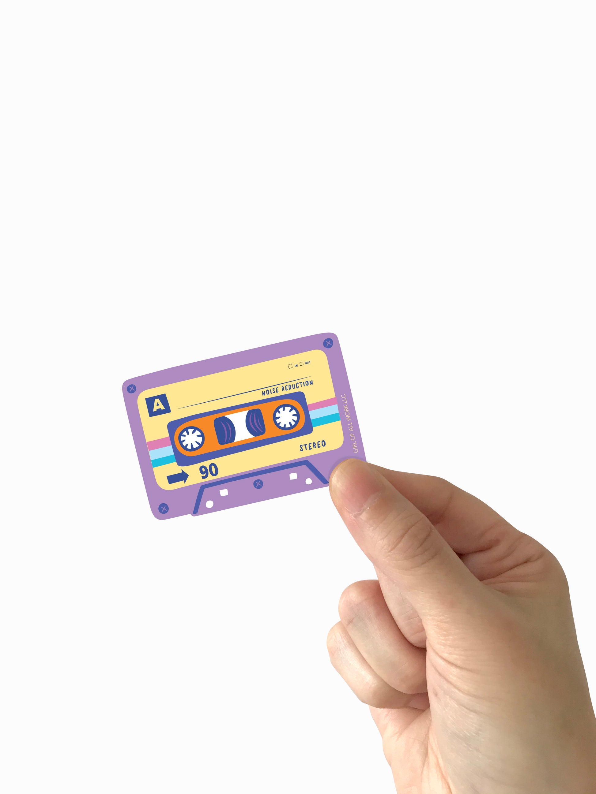 Hand holding a colorful vinyl sticker cassette tape against a white background