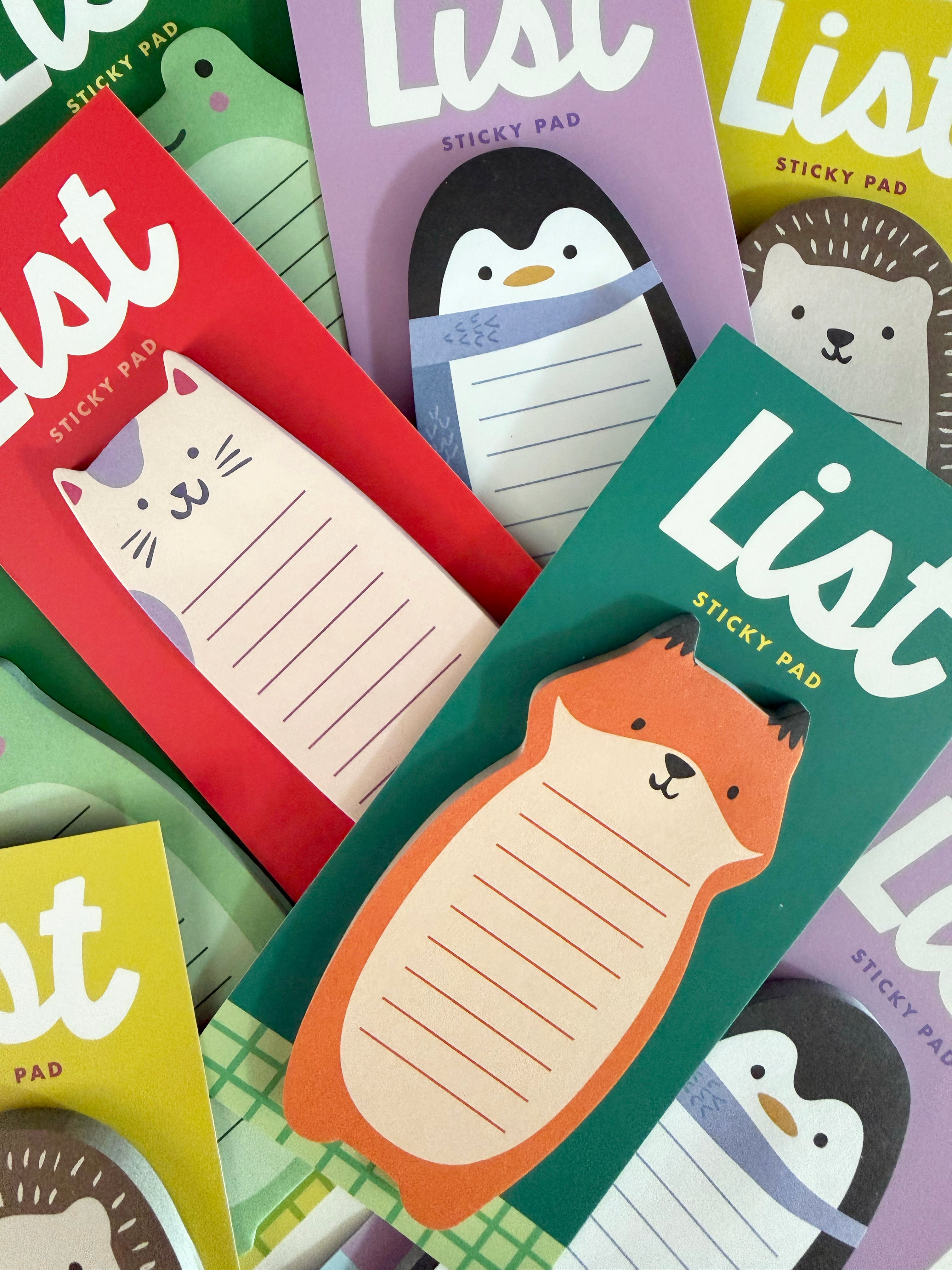 A close-up, top-down view of several colorful sticky pads with cute animal illustrations, including a fox, penguin, bear, and cat, arranged overlapping each other.