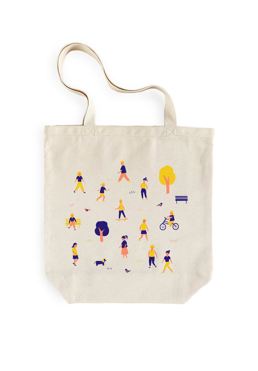 Beige tote bag with colorful illustrations of people and objects at a park on a white background